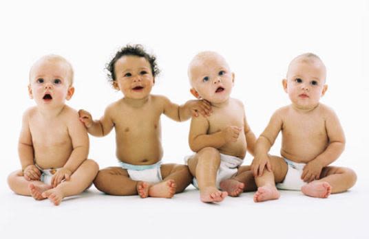 image of four babies in diapers sitting up on the floor, white background