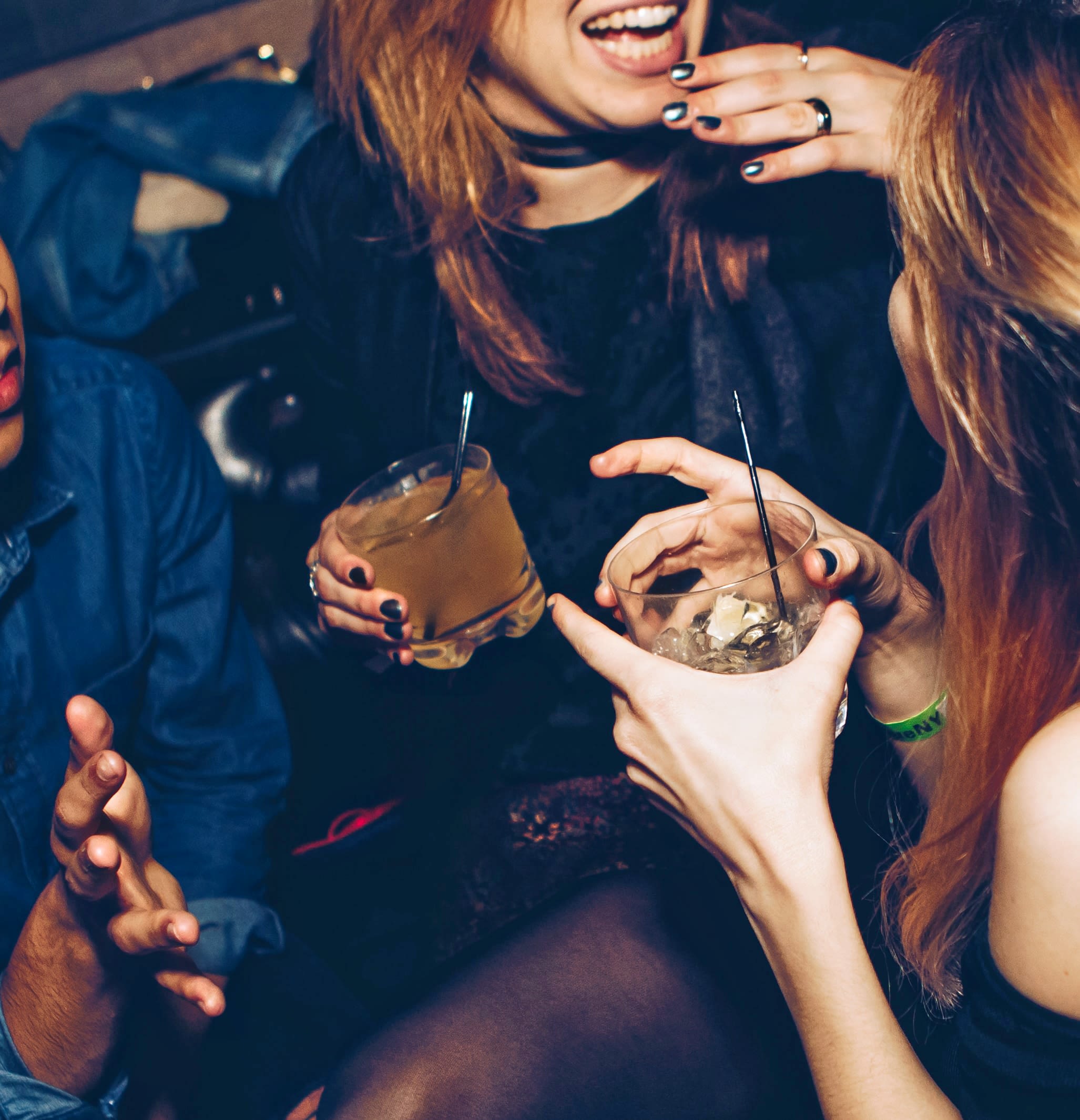 two women talking while holding drinking glasses